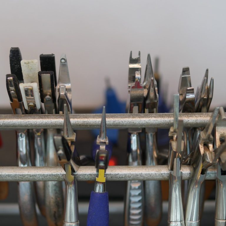 Eine Auswahl an verschiedenen Zangen auf einem Halter.