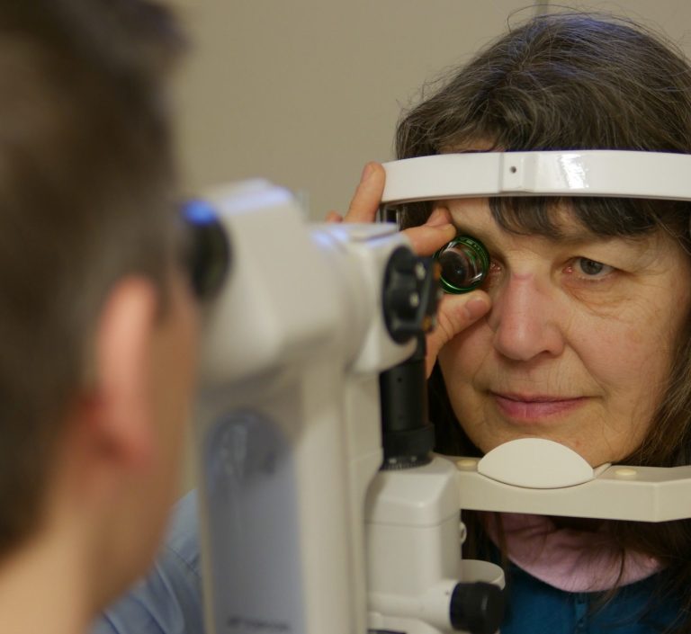 Augenuntersuchung: Optiker nutzt eine Volklinse zur Untersuchung des Auges einer Patientin.